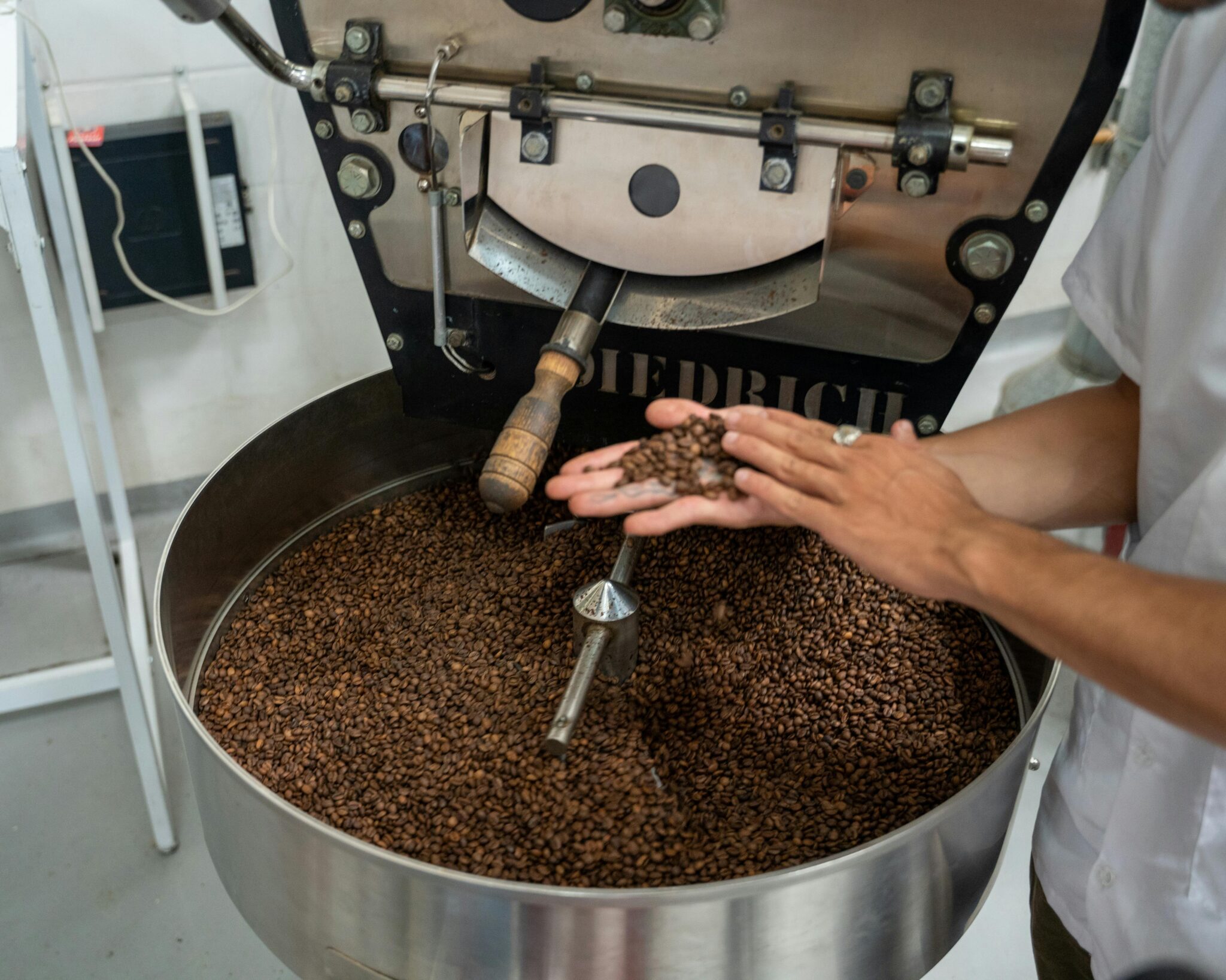 Close-up of coffee beans being roasted in a large industrial roaster, showcasing the process.